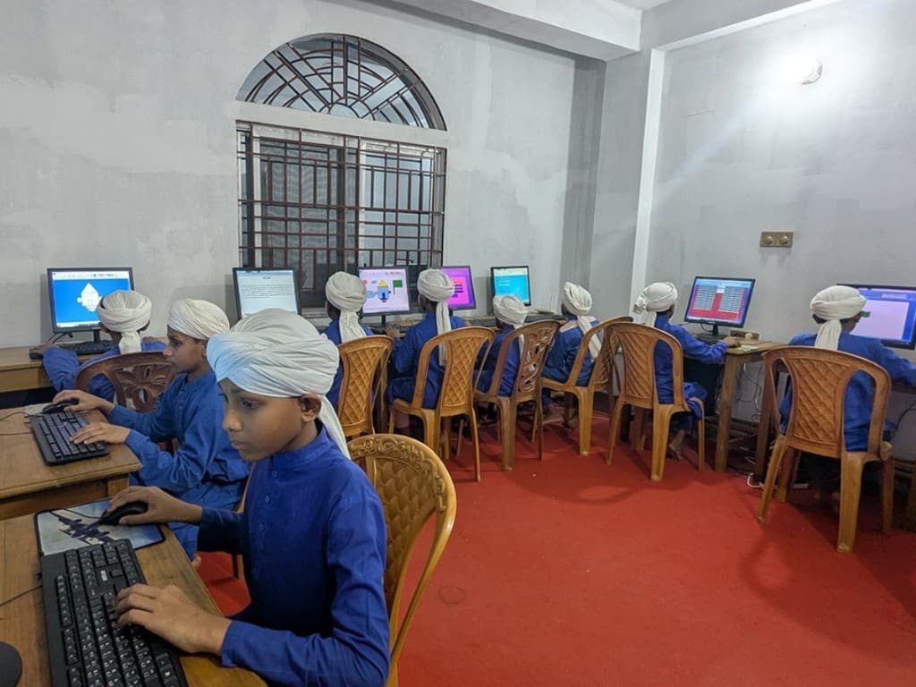 Madrasa students learning at computers in a classroom
